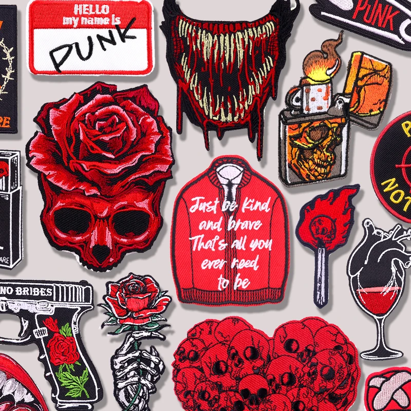 Red skull and rose embroidered patches with flames, punk slogans, weapons, and gothic icons on grey background