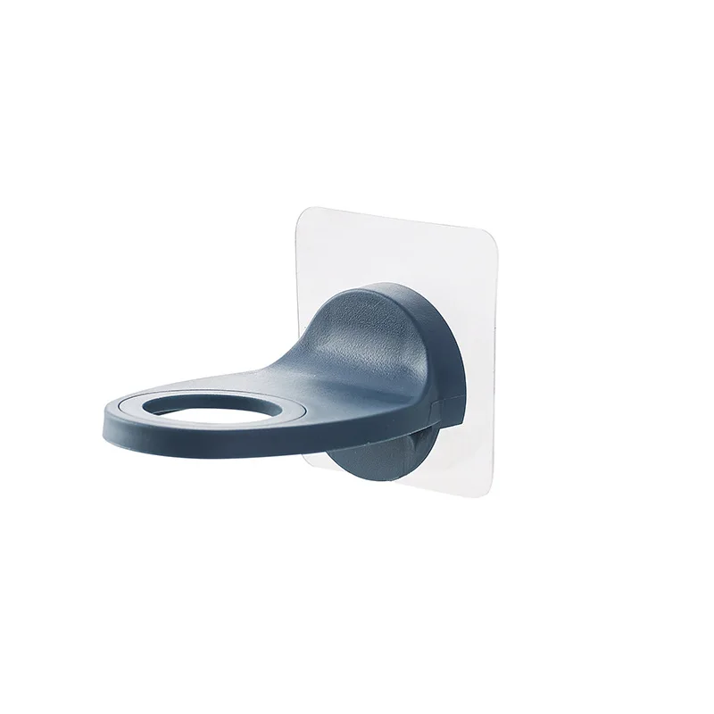 Distributeur gel hydroalcoolique installe sur carrelage, main appuyant sur la pompe pour distribution du gel.