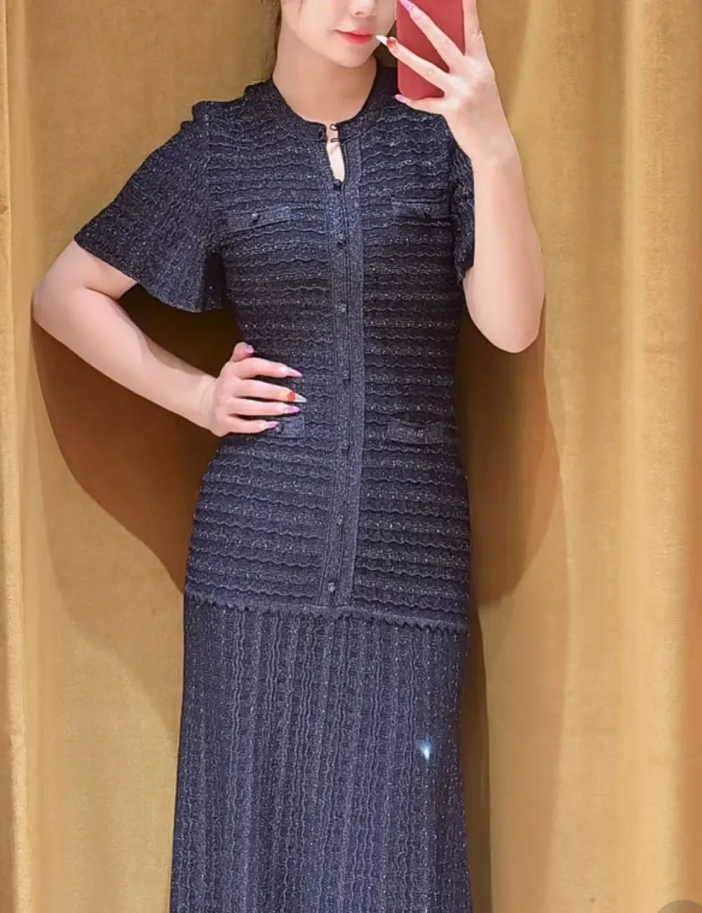 فستان كحلي طويل بتفاصيل لامعة وأكمام واسعة