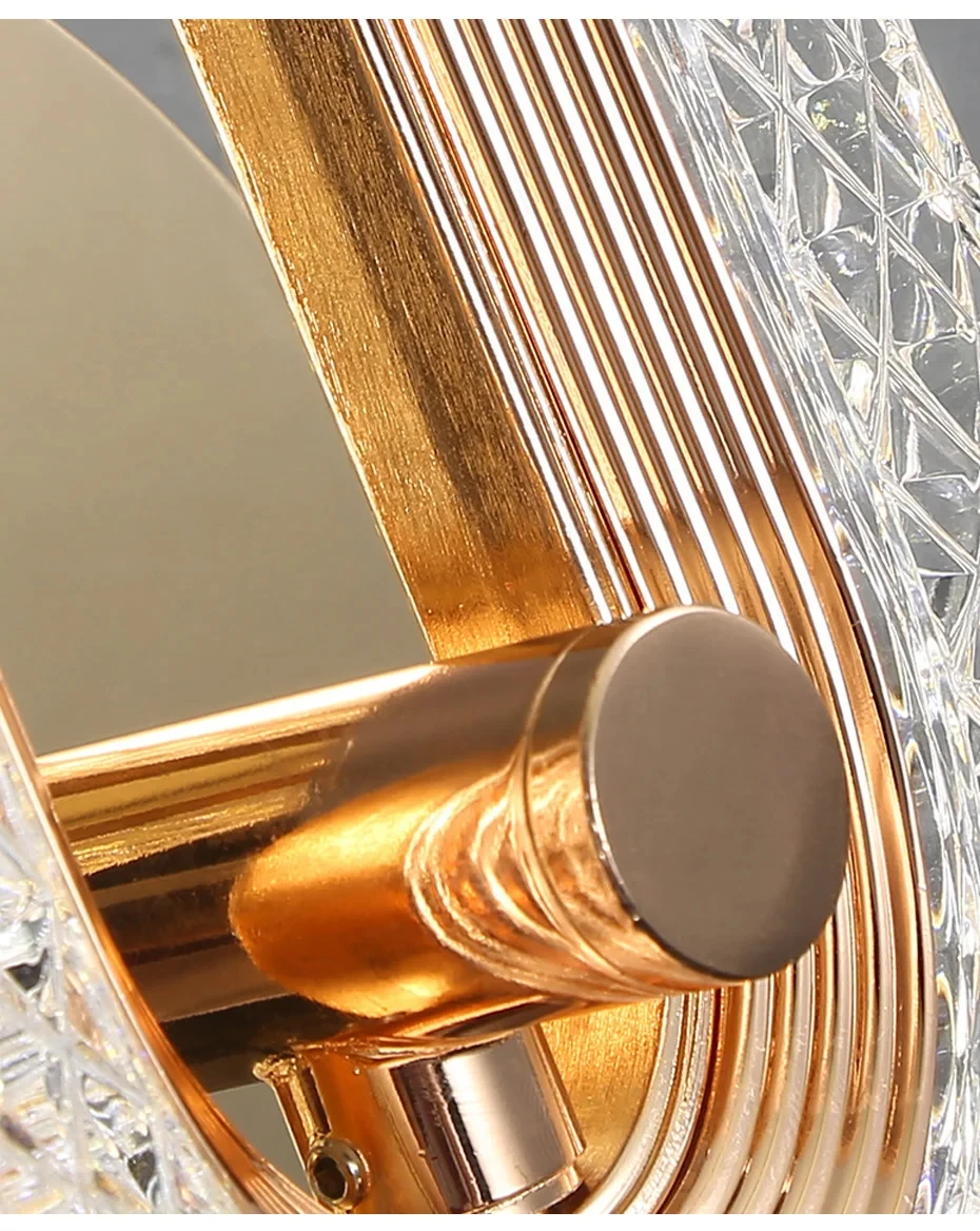 Close-up of the Luxury Wall Sconce, a modern and stylish decorative piece featuring gold-toned metal and clear faceted crystal elements. The LED design includes cylindrical and ribbed textures, making it perfect for enhancing your indoor lighting decor.