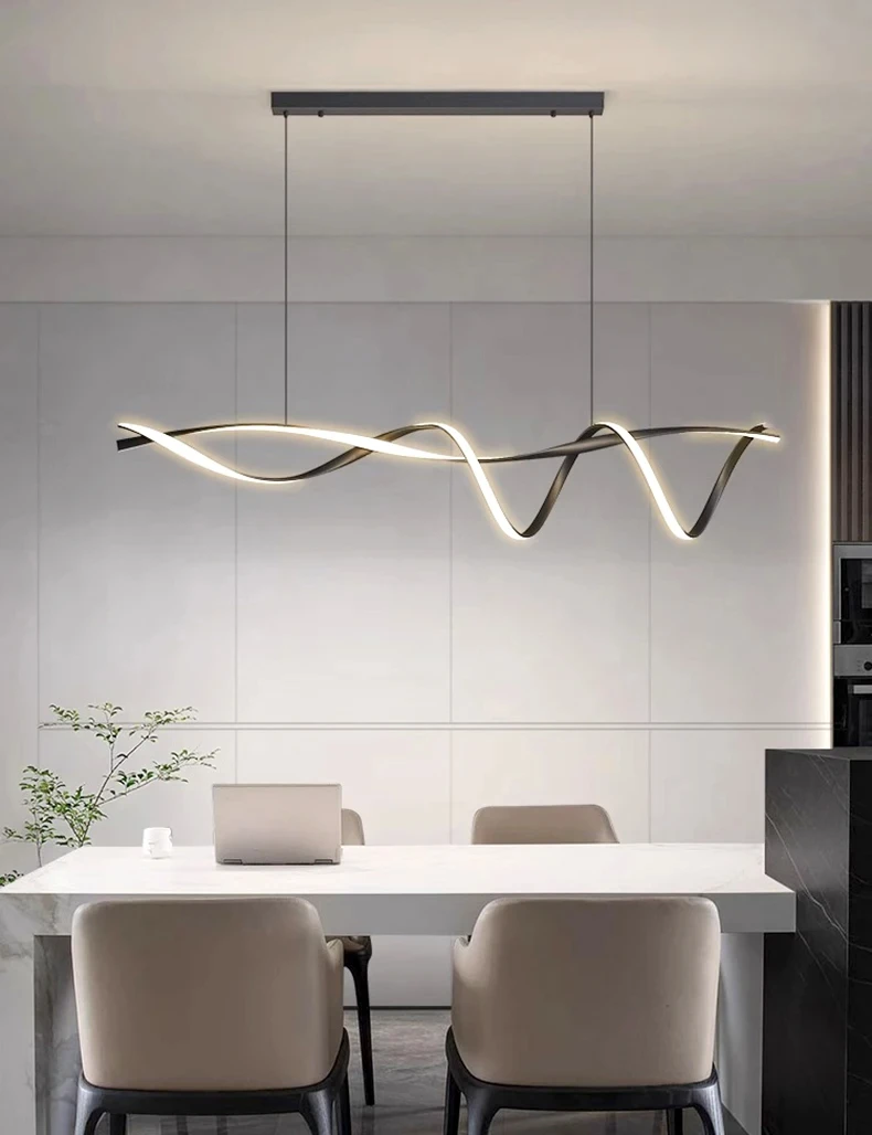 A modern dining area boasts a Stylish Pendant Light illuminating the table set for three, with simple chairs and a laptop resting on the table, all set against a minimalistic backdrop.