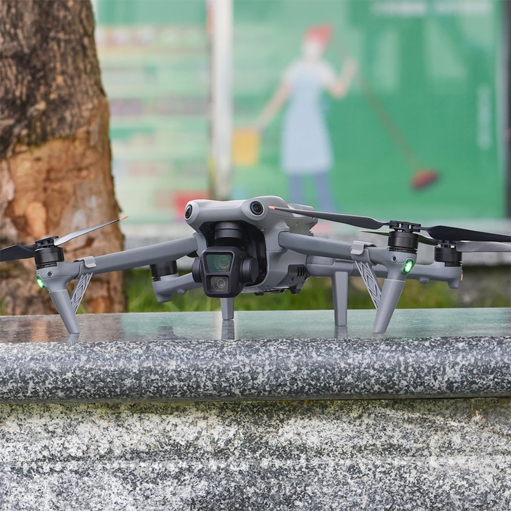 Achetez le support de train d'atterrissage à dégagement rapide pour DJI Air 3 / Air 3S, montré ici protégeant le drone lors de l'atterrissage sur herbe.