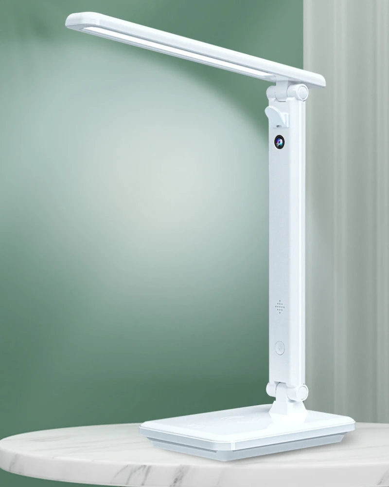 A white SpyCam Desk Lamp on top of a table, featuring remote monitoring capabilities for smartphone usage.