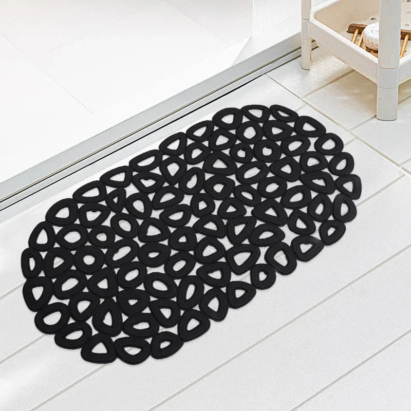 White non-slip suction bath mat with circular holes on a wet shower floor.