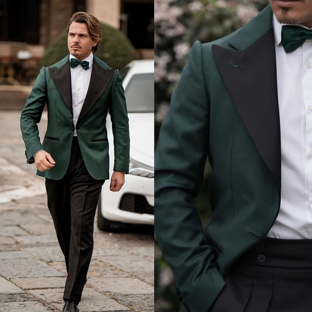 Urban Fashion. Dressing In A Black Blazer, Green Necktie, White Undershirt, Green  Pants, A Young Black Guy With Mohawk Hair Is Standing By A Rocky Fence,  Relaxing, Thinking. Man Relaxing Outside. Stock