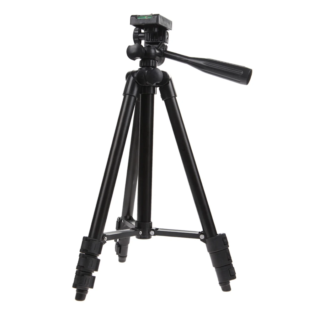 Trépied universel en aluminium déployé sur un sol herbeux, support stable pour caméra action, prêt à filmer en extérieur.