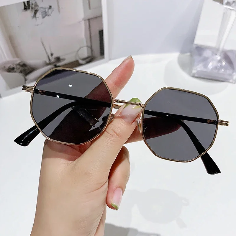 Classic multi-faceted sunglasses for women with a trendy brand, featuring a small metal frame and adorned with gold, gradient sunglasses.