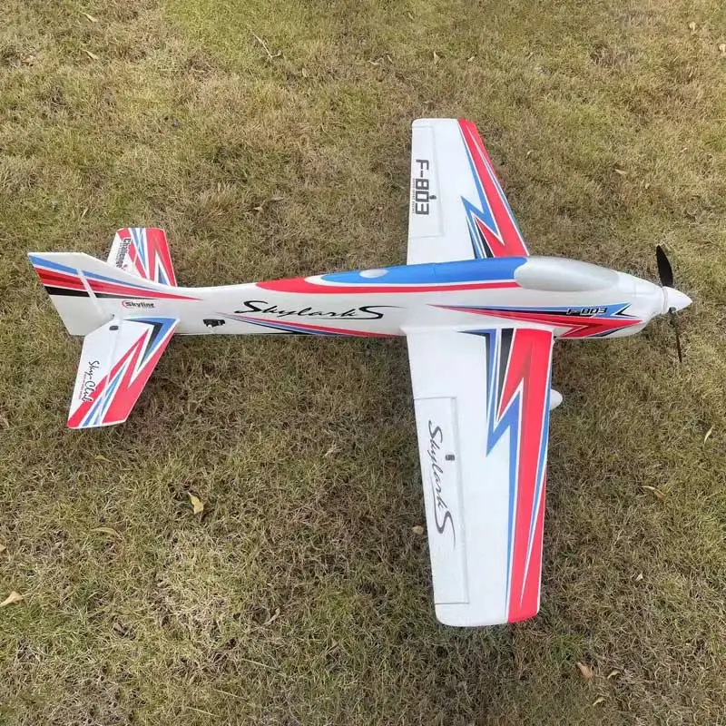 Avion RC KIT/PNP rouge vu de côté, ailes détaillées et hélice, idéal pour débutants et experts