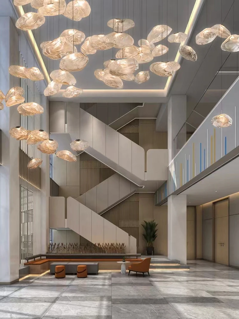 Modern lobby with marble floors, geometric staircase, glass railings, wall art, a brown chair, and a Luxe Cloud Glass Pendant Light suspended from the ceiling.