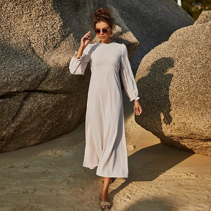 Woman relaxing at resort in modest clothing Islamic dress with sun protection