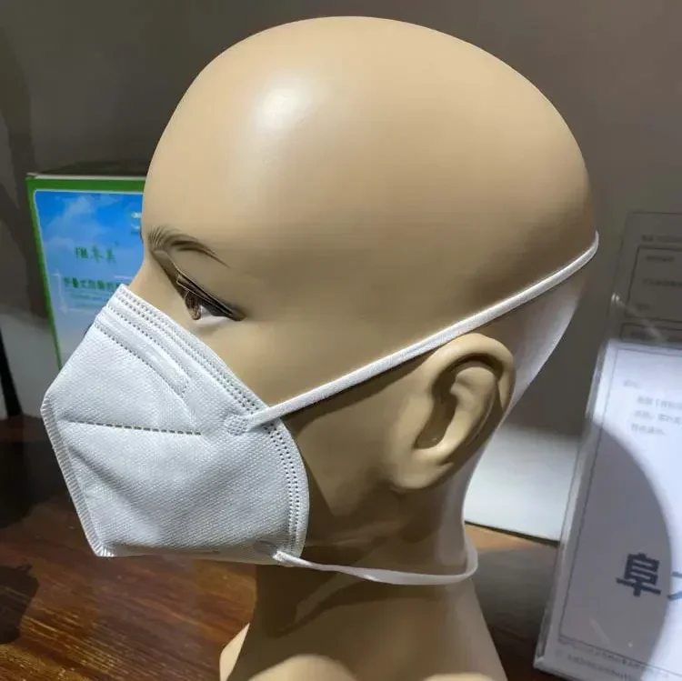 Détail des attaches élastiques blanches d'un masque de protection respiratoire.