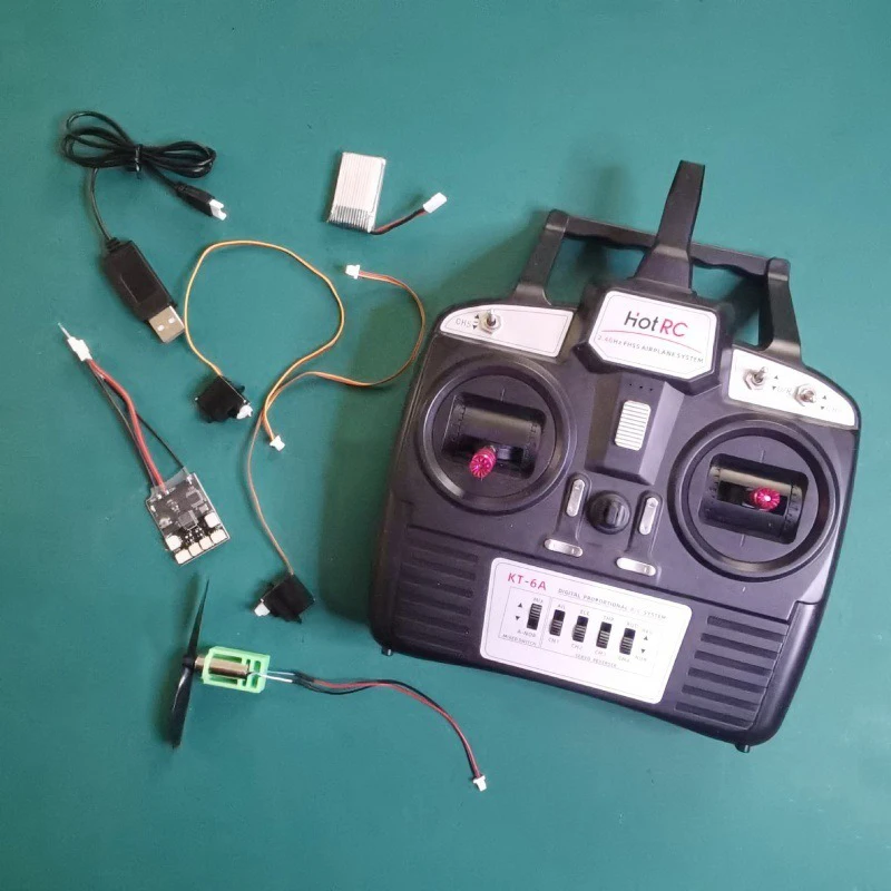 Télécommande incluse dans le kit avion RC KT Board complet, avec manches et interrupteurs.