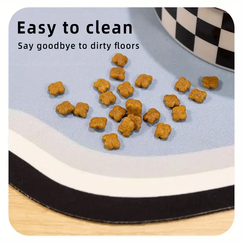 A close-up view of dry pet food scattered on a blue feeding mat with the text "Easy to clean, Say goodbye to dirty floors".