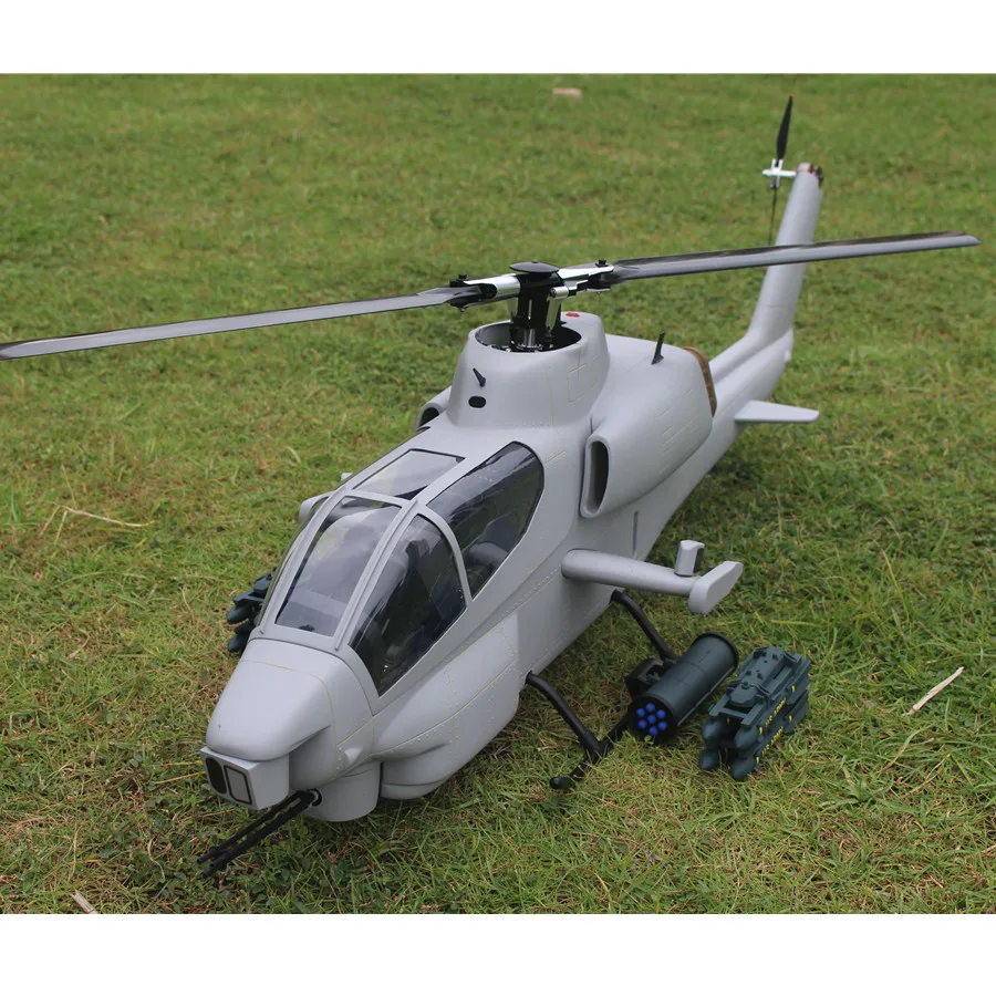 Hélicoptère RC professionnel BNF/RTF 2.4GHz en vol, avec le paysage en arrière-plan flou, capturant le mouvement dynamique.