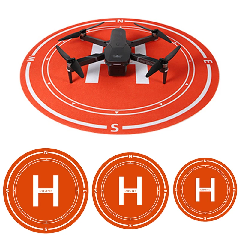 Tapis d'atterrissage pour drone rond, antidérapant et imperméable, posé sur herbe avec drone prêt à atterrir.