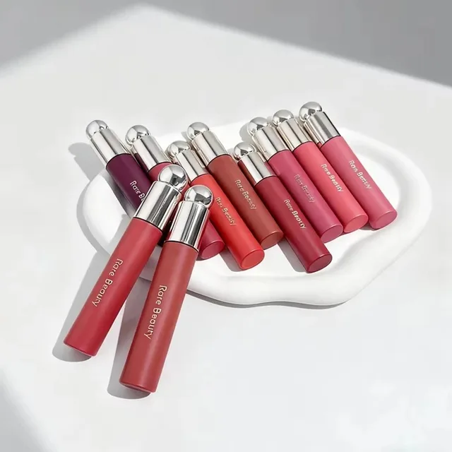 Rare Beauty Blush Lip Gloss illumine le teint, est soyeux et magnifique, et rehausse les contours. Maquillage pour filles et femmes avec boîte. 1