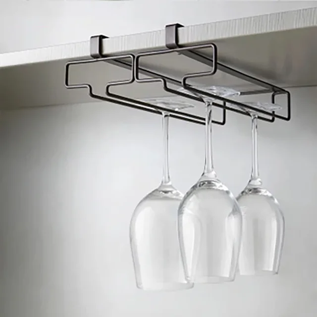 A black under cabinet wine glass rack holding three clean wine glasses, installed beneath a modern white kitchen cabinet.
