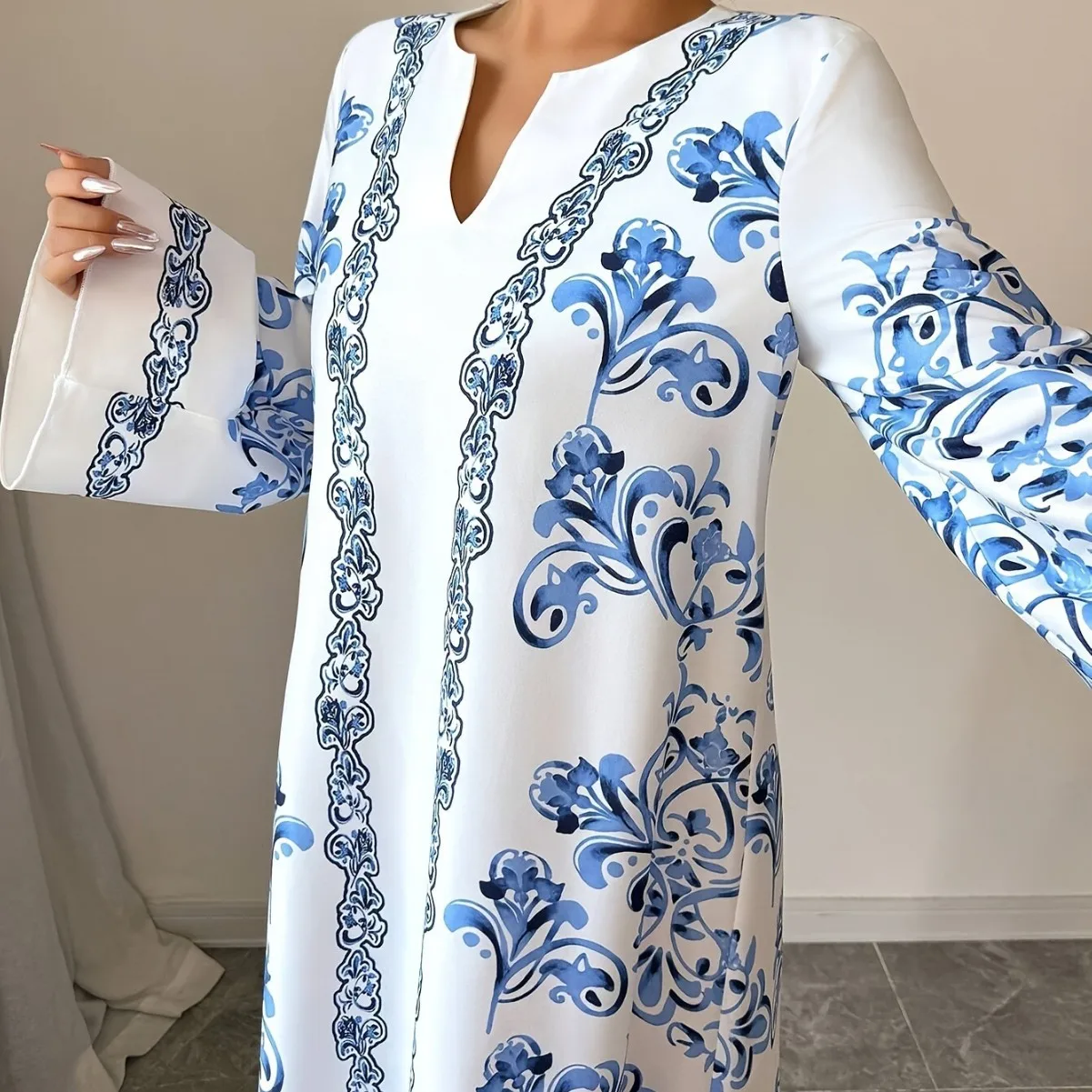 جلابية بيضاء طويلة بنقوش زرقاء وأكمام واسعة