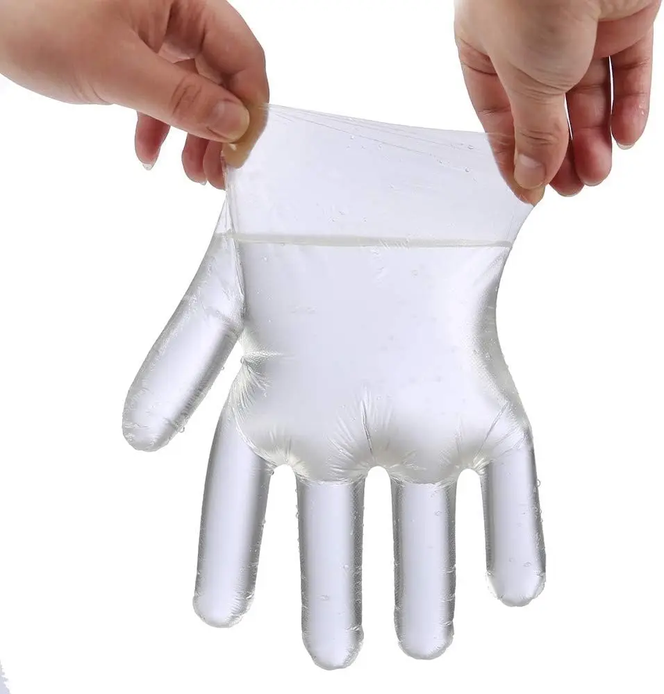 Mains portant des gants vinyle jetables alimentaires manipulant des aliments, démonstration d'usage.