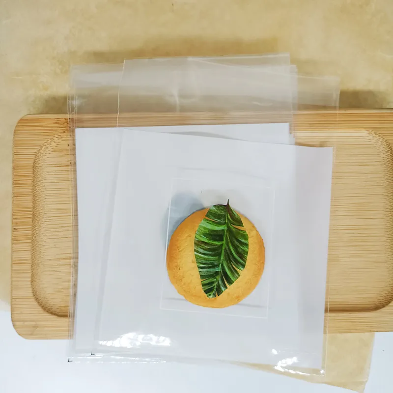 thumbnail image 1 of 50/100P 10x10cm Bolsas de regalo con lazo Bolsas de plástico autoadhesivas para galletas de boda Paquetes de pasteles de dulces de cumpleaños, 1 of 5