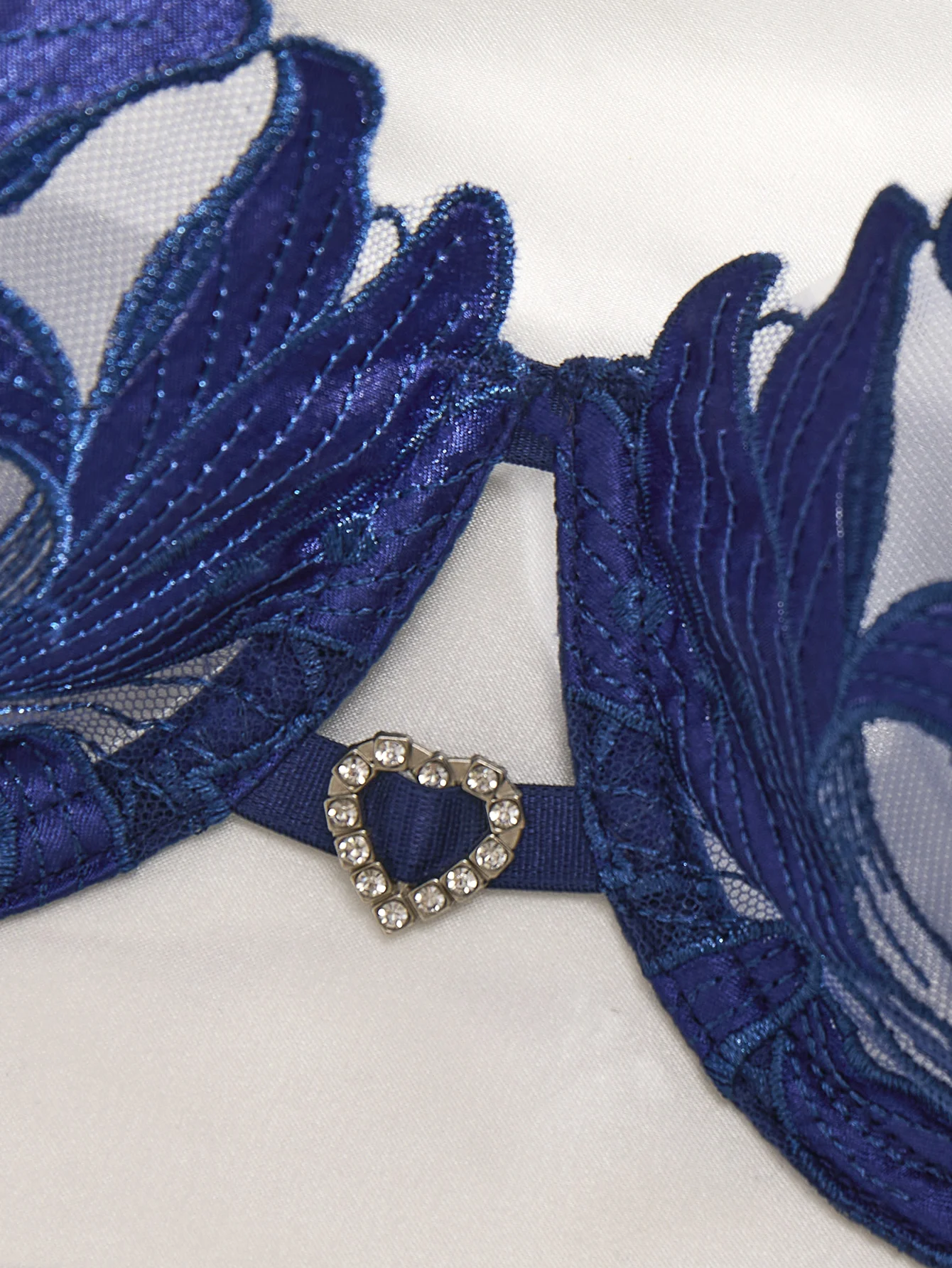 Close-up of blue floral embroidery with transparent mesh texture and delicate trim