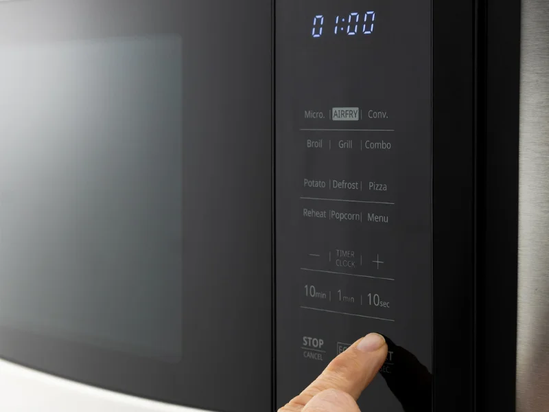 Someone using microwave touch pad.