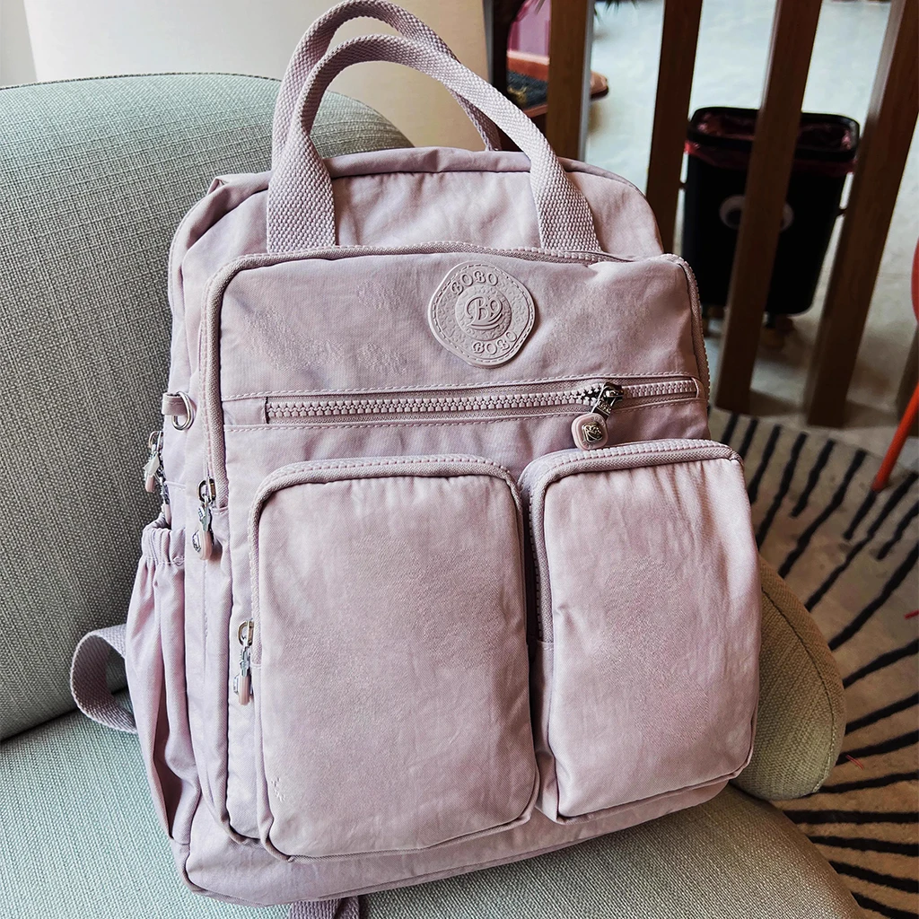 حقيبة ظهر نسائية متعددة الجيوب، تتميز بمقبض علوي ن...