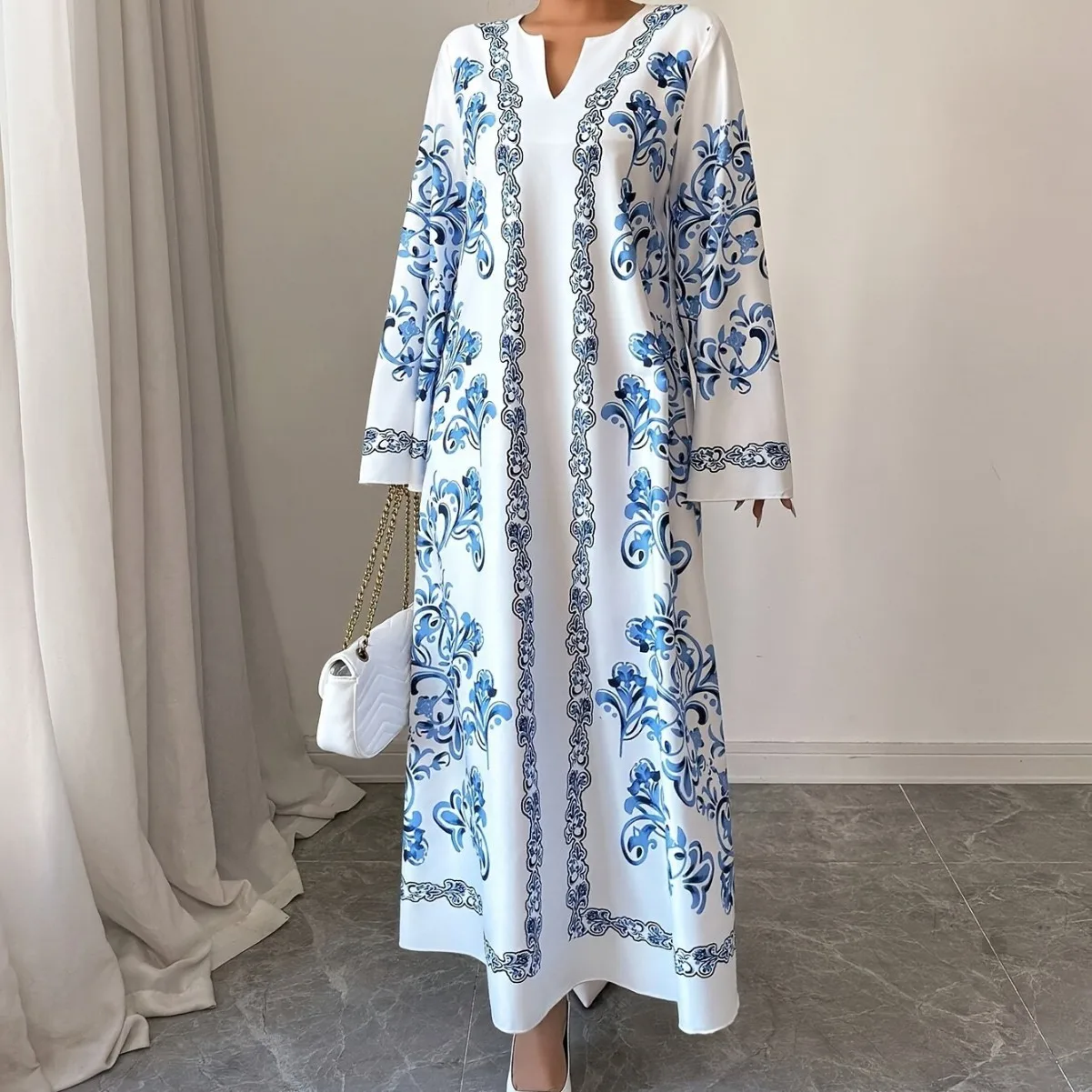جلابية بيضاء طويلة بنقوش زرقاء وأكمام واسعة