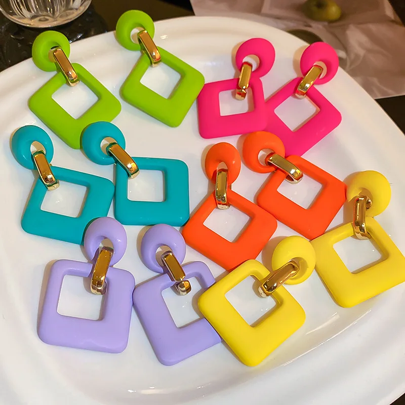Trendsetting square drop earrings worn by woman