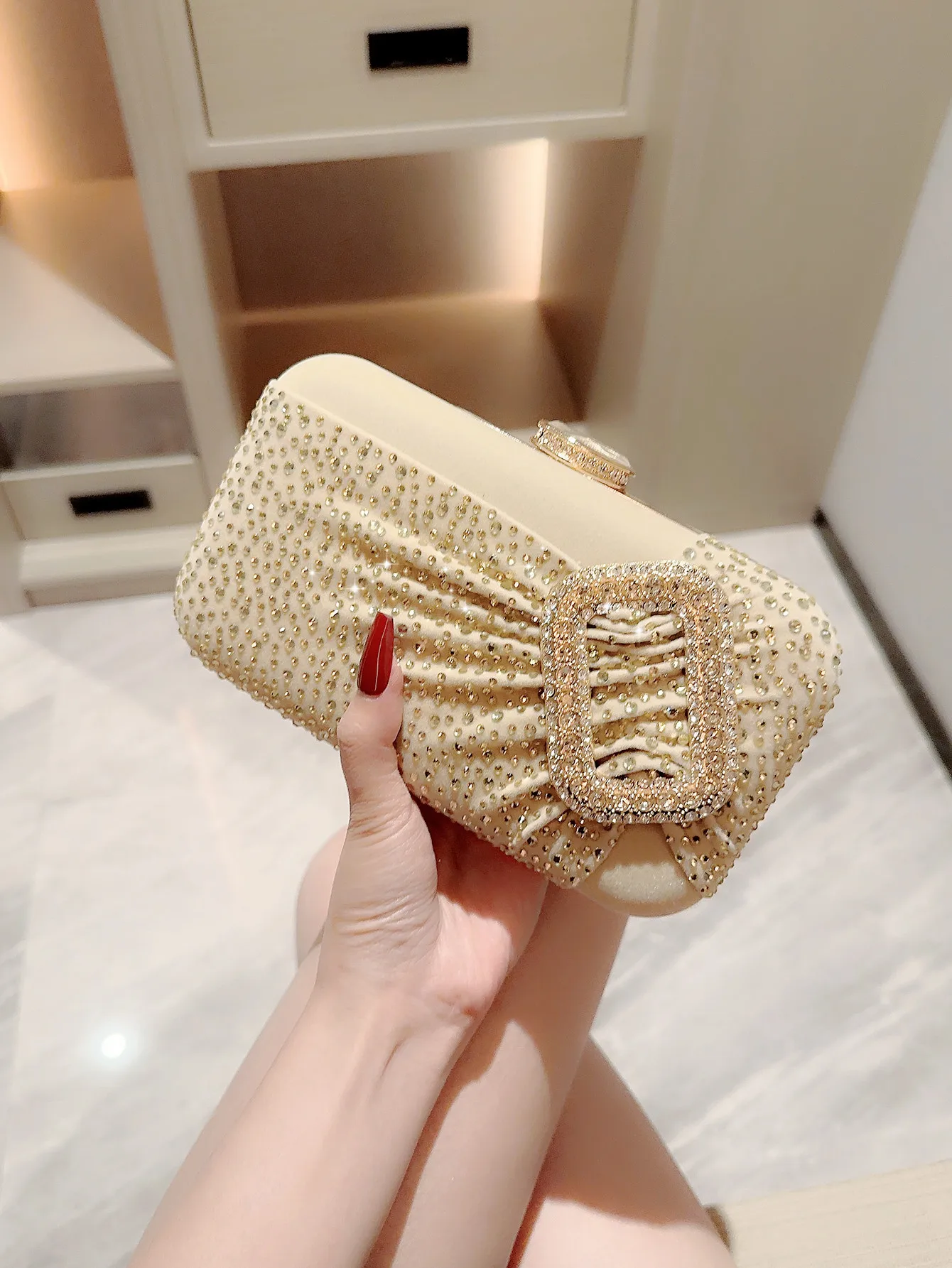 Female hand is holding a small golden clutch bag with a metal chain Stock  Photo by ndanko