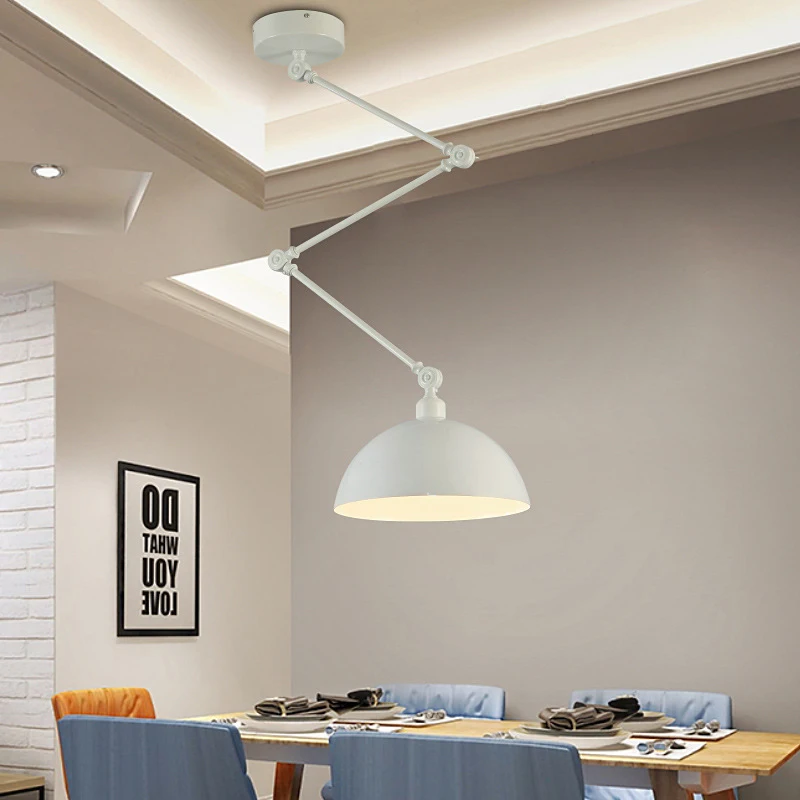 Modern dining area with a Zig Zag Pendant Light, wooden table, blue chairs, and decorative wall sign.