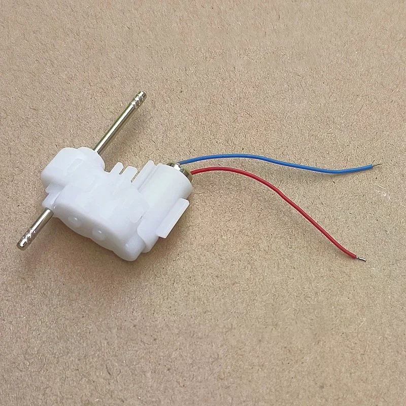 Mini moteur à engrenages sans noyau 614 côte à côte avec une pièce de monnaie pour échelle, pour bricolage et voiture jouet.