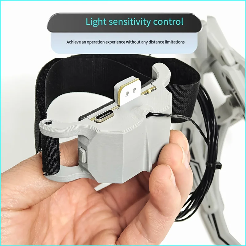 Gros plan sur le capteur lumineux et le mécanisme de la griffe, avec câble de connexion visible. Achetez le Lanceur Airdrop à Capteur Lumineux pour DJI Mavic 2, Air 2, Mavic 3, Mavic 4.