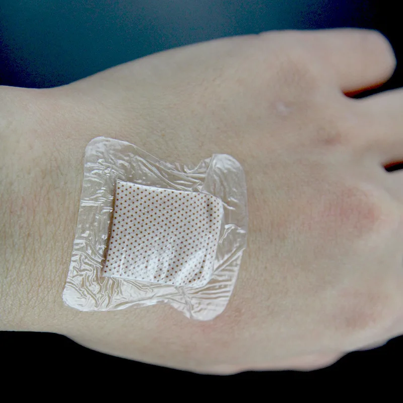 Application d'un pansement adhésif imperméable PU sur une main, démonstration d'utilisation.