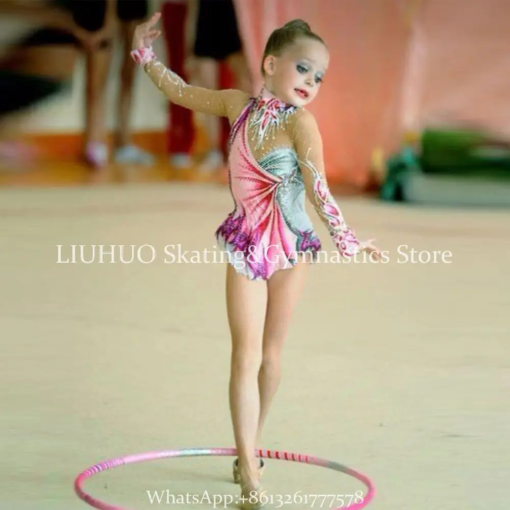 Niña gimnasta con un leotardo brillante para actuaciones y con un aro en  las manos.