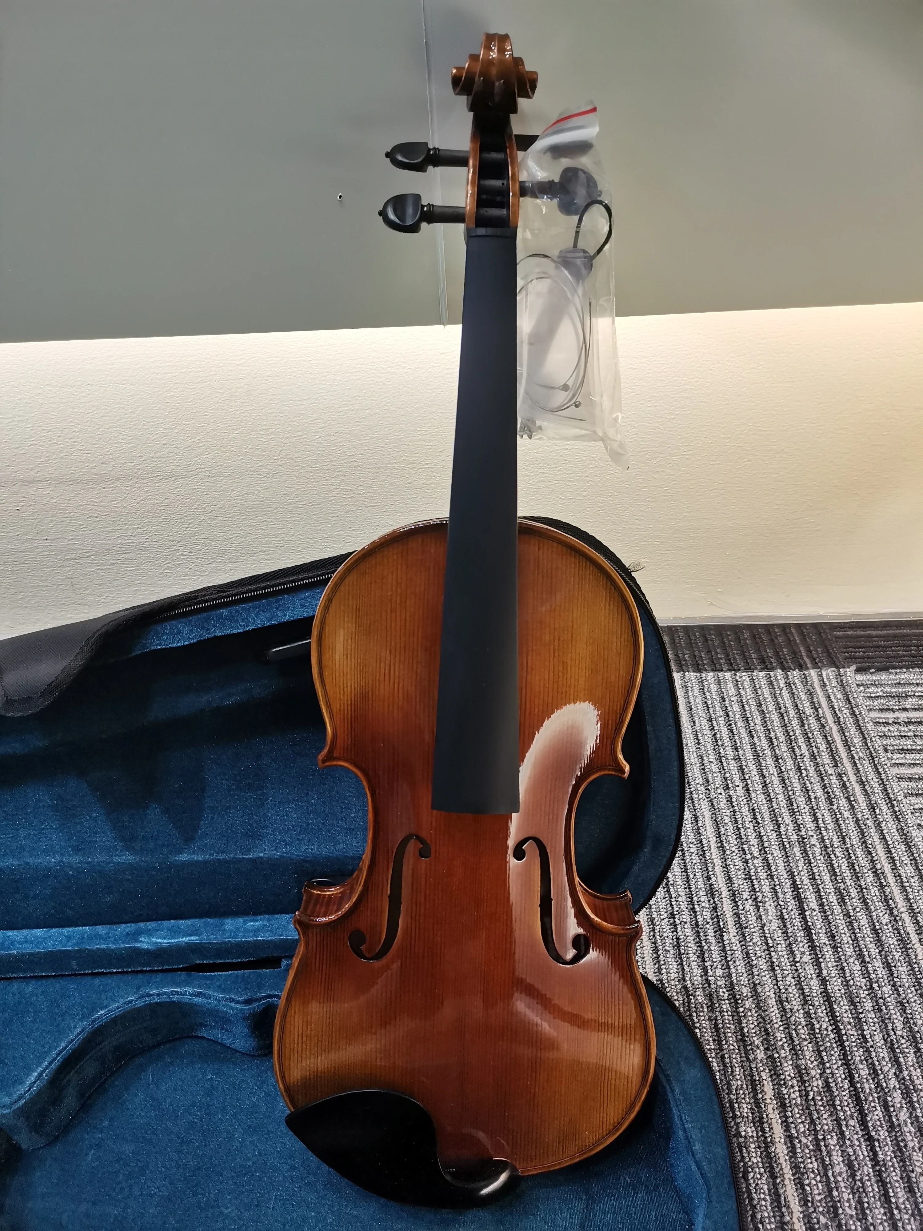 4/4 high-end handmade Italian violin with ebony flat knobs and vintage lacquer, featuring strings, bow, and case.