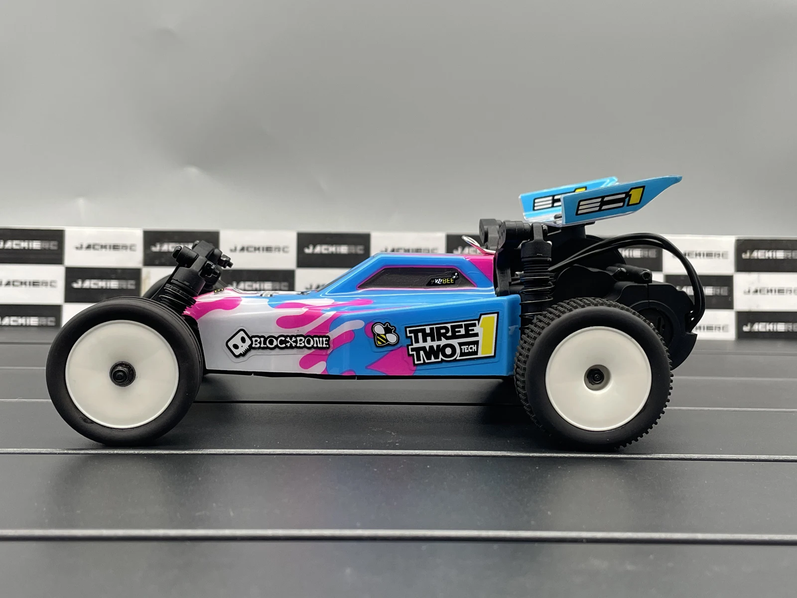 Vue de dessus de la voiture télécommandée crawler RC MB24 4WD 1/24 RTR montrant les détails du châssis et des pneus.
