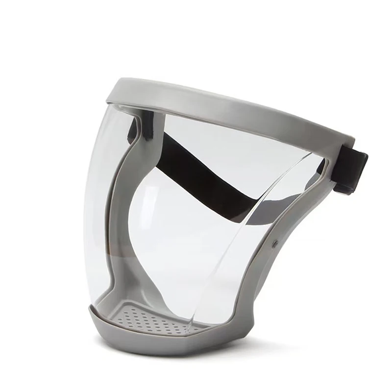 Vue rapprochée du masque intégral transparent sur fond blanc, détaillant les trous d'aération et les lentilles.