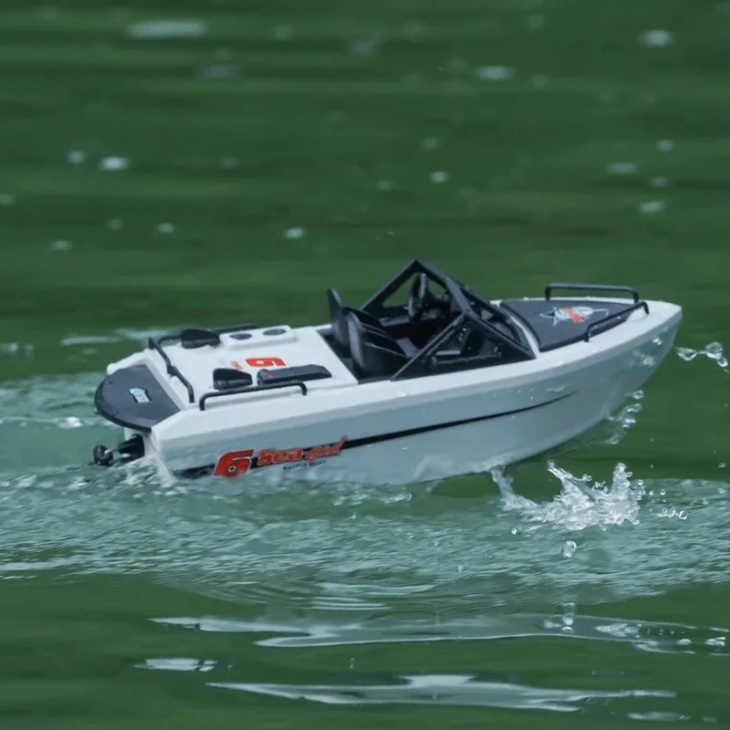 Gros plan sur la télécommande 2.4GHz et le bateau radiocommandé rapide, prêt à l'emploi.
