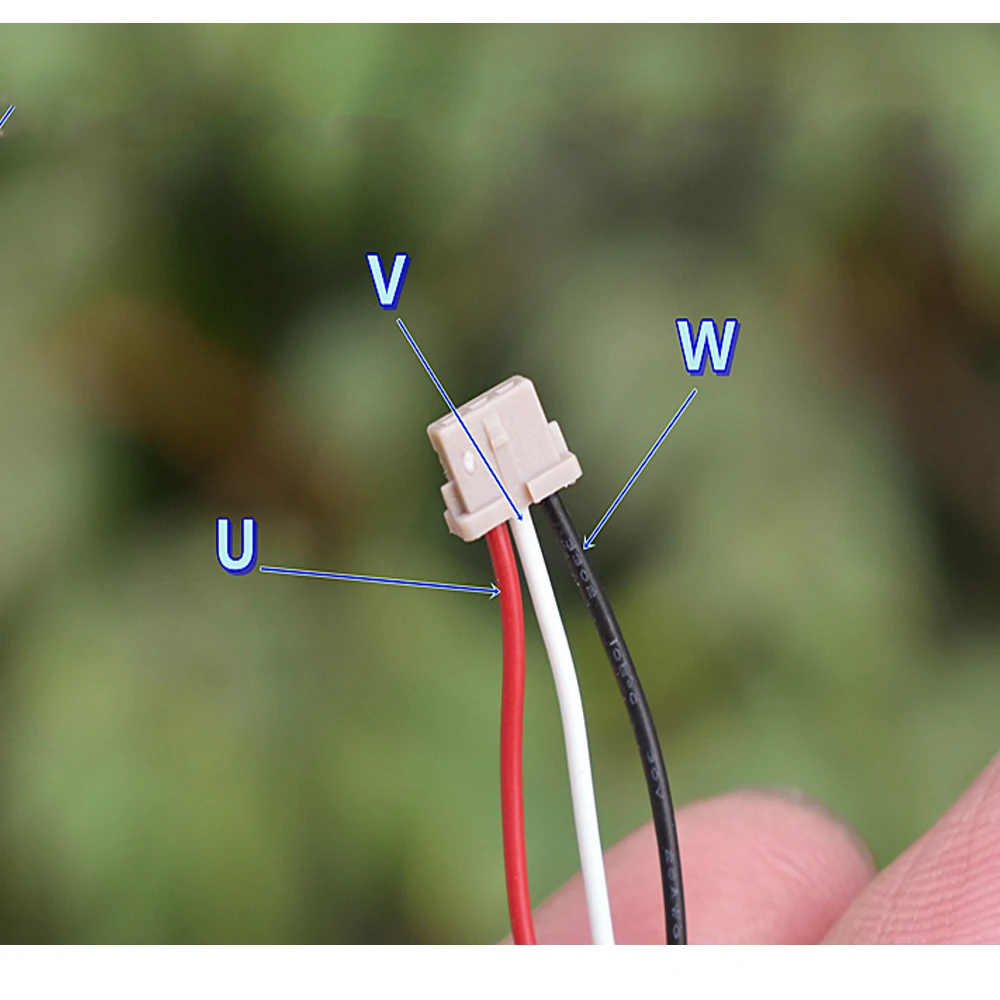 Moteur sans balais pour avion RC posé sur une surface, avec une pièce de monnaie pour échelle, illustrant sa taille compacte.