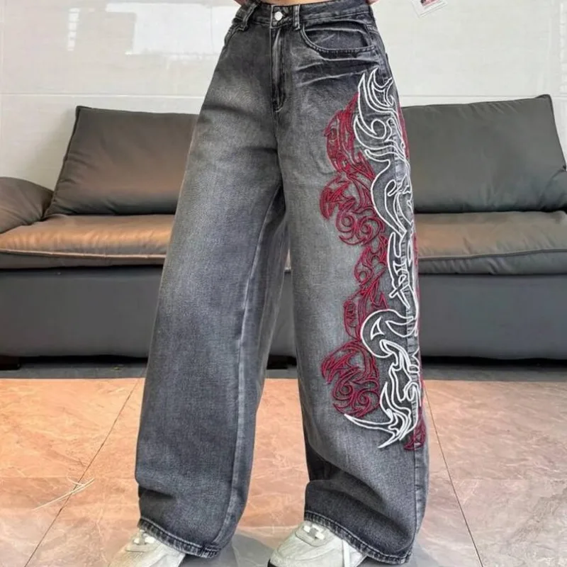 Jean vintage gris foncé délavé pour femme, taille haute, coupe large, avec broderie abstraite rouge et blanche sur le côté, en denim, collection été 2026, style streetwear européen