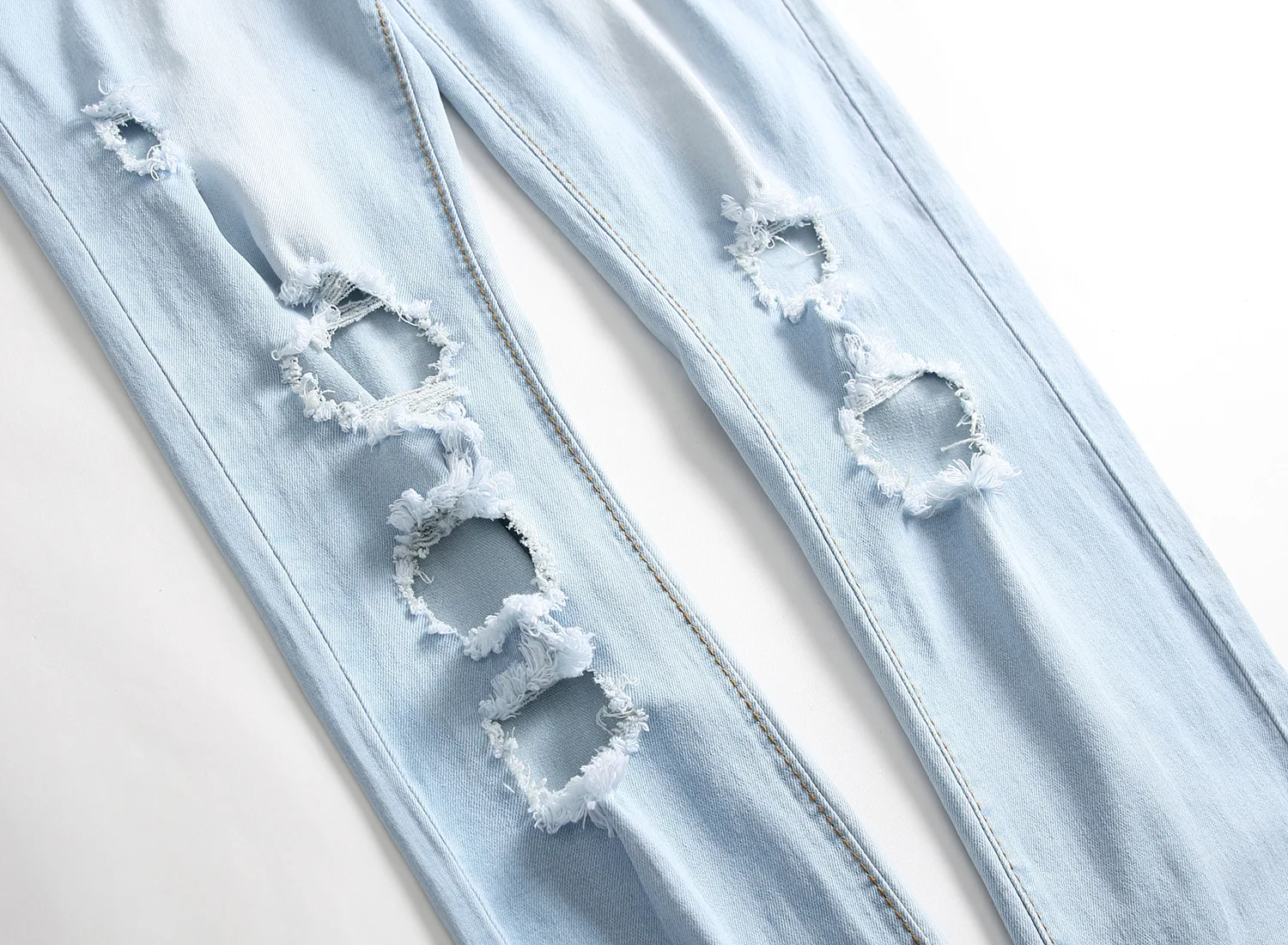 Close-up of distressed ripped detail on light blue Valroze™ Embroidered Denim Jeans