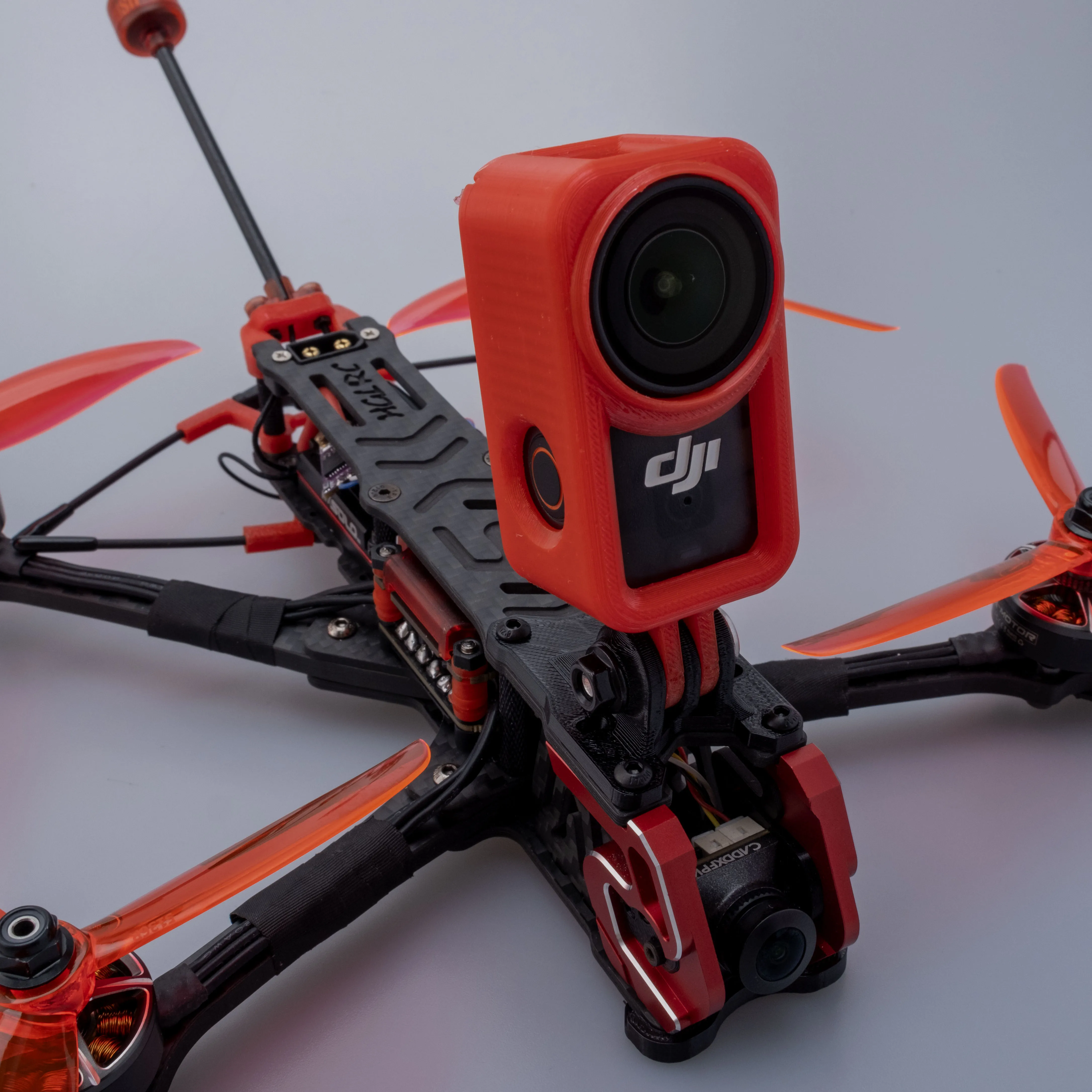 Module caméra drone rouge, connecteurs visibles, pièce détachée pour drone.