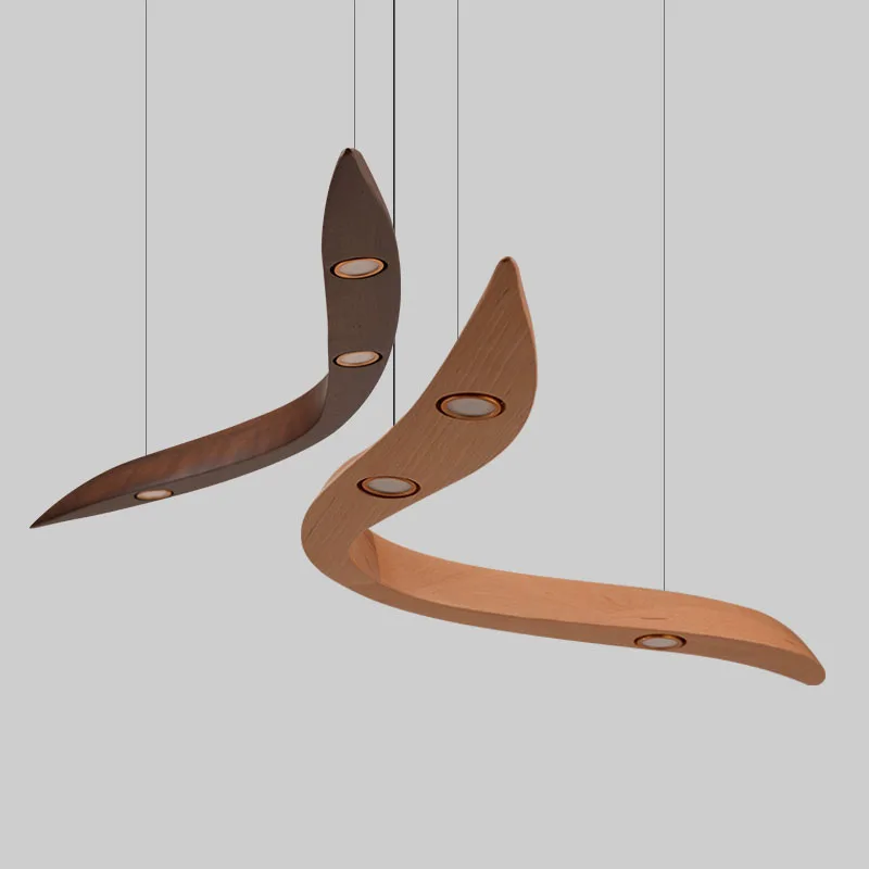 Two Spiral Wood Pendant Lights, one dark brown and one light brown, each with three circular embedded bulbs, are suspended from the ceiling against a plain background.
