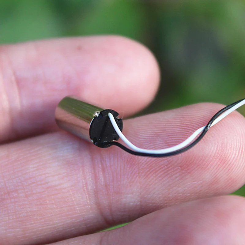Deux mini moteurs 6x10mm sans noyau 3.7V CC pour RC, avec des hélices miniatures en arrière-plan.