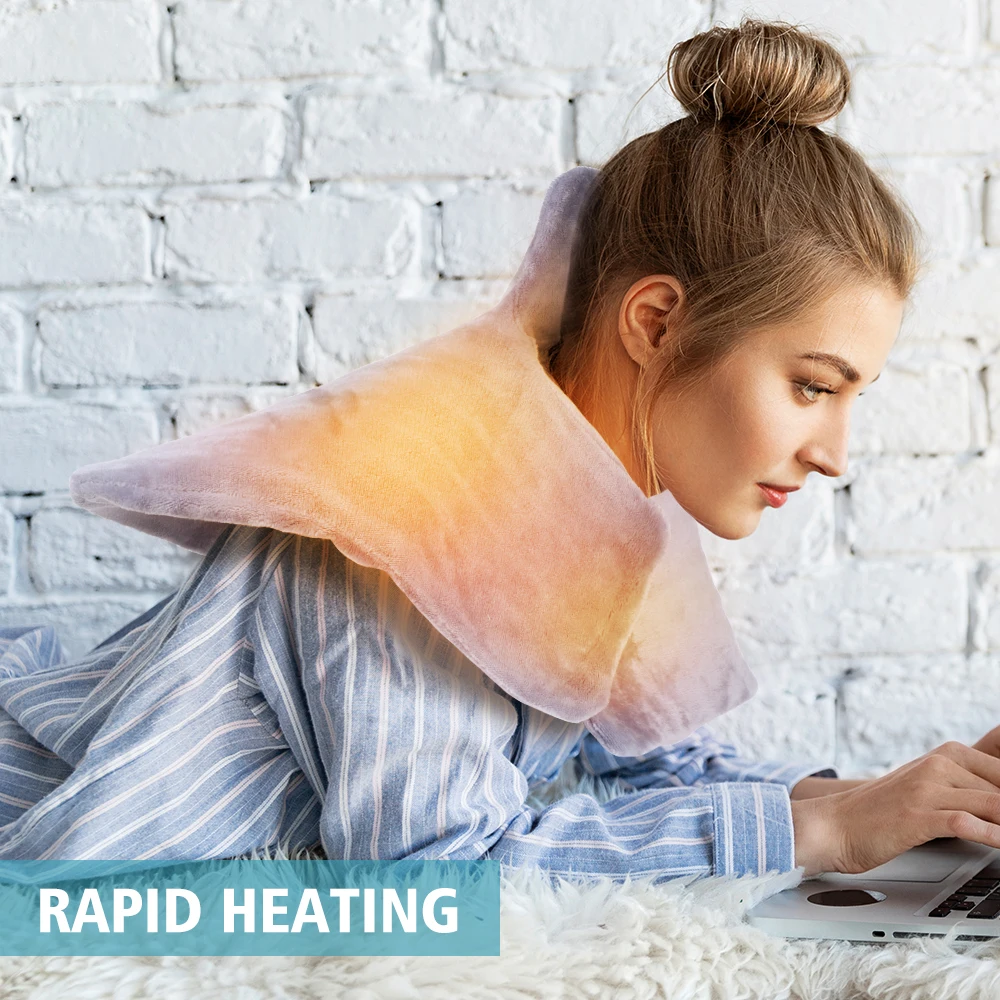 A woman using a lightweight electric heated shawl on her laptop.