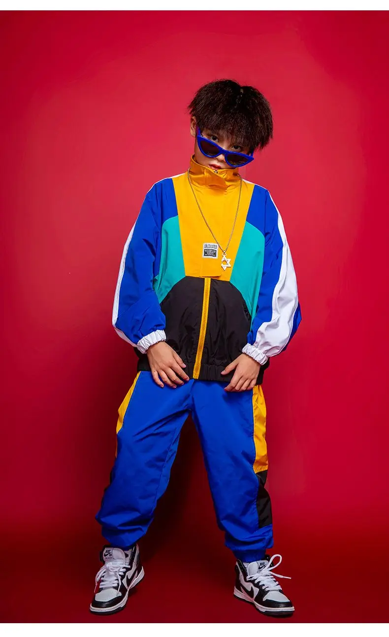 Child wearing patchwork jacket and joggers in hip hop street dance pose 65