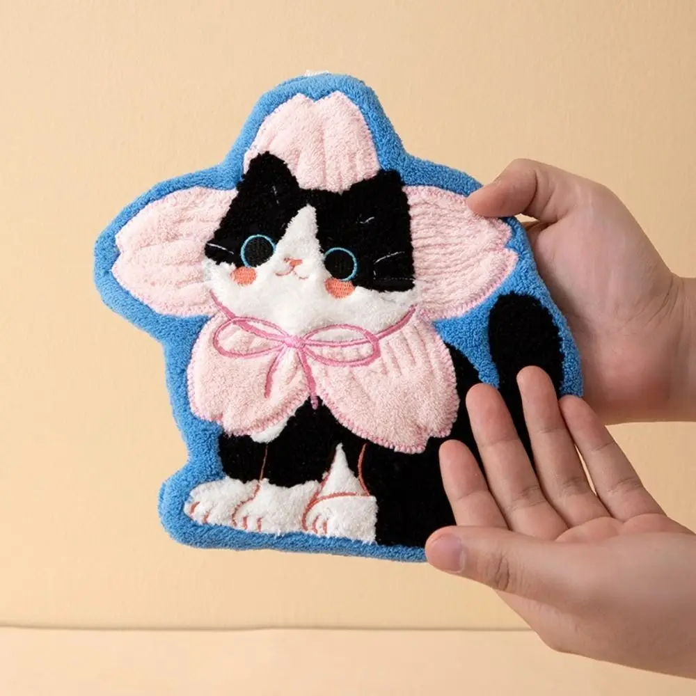 Someone holds a KittyNook Cat Co. Premium Coral Fleece Kitchen Towel with a pink flower on a blue background.