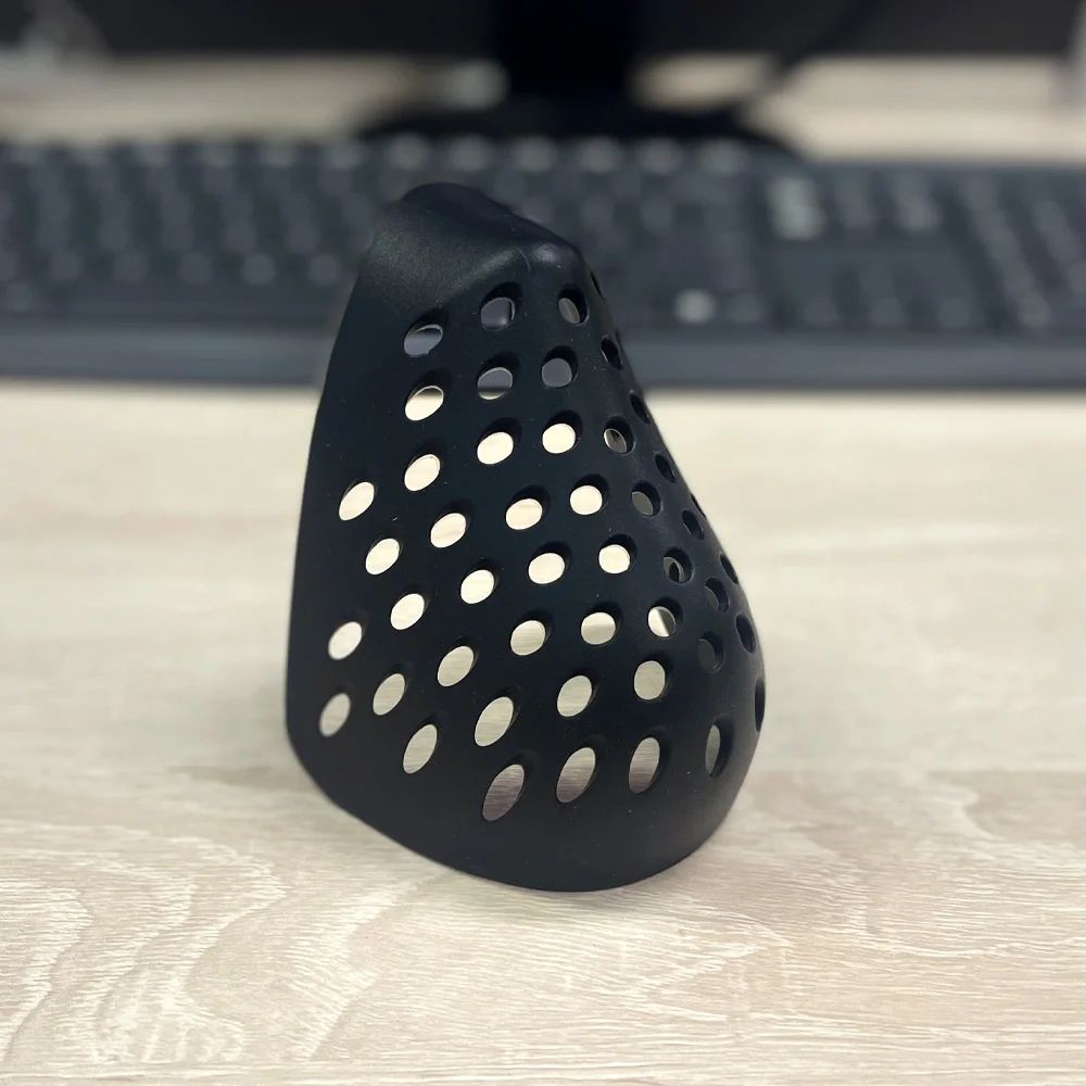 Demi-masque en silicone gris sur une table, vue de face montrant les valves de filtration et le design ergonomique.