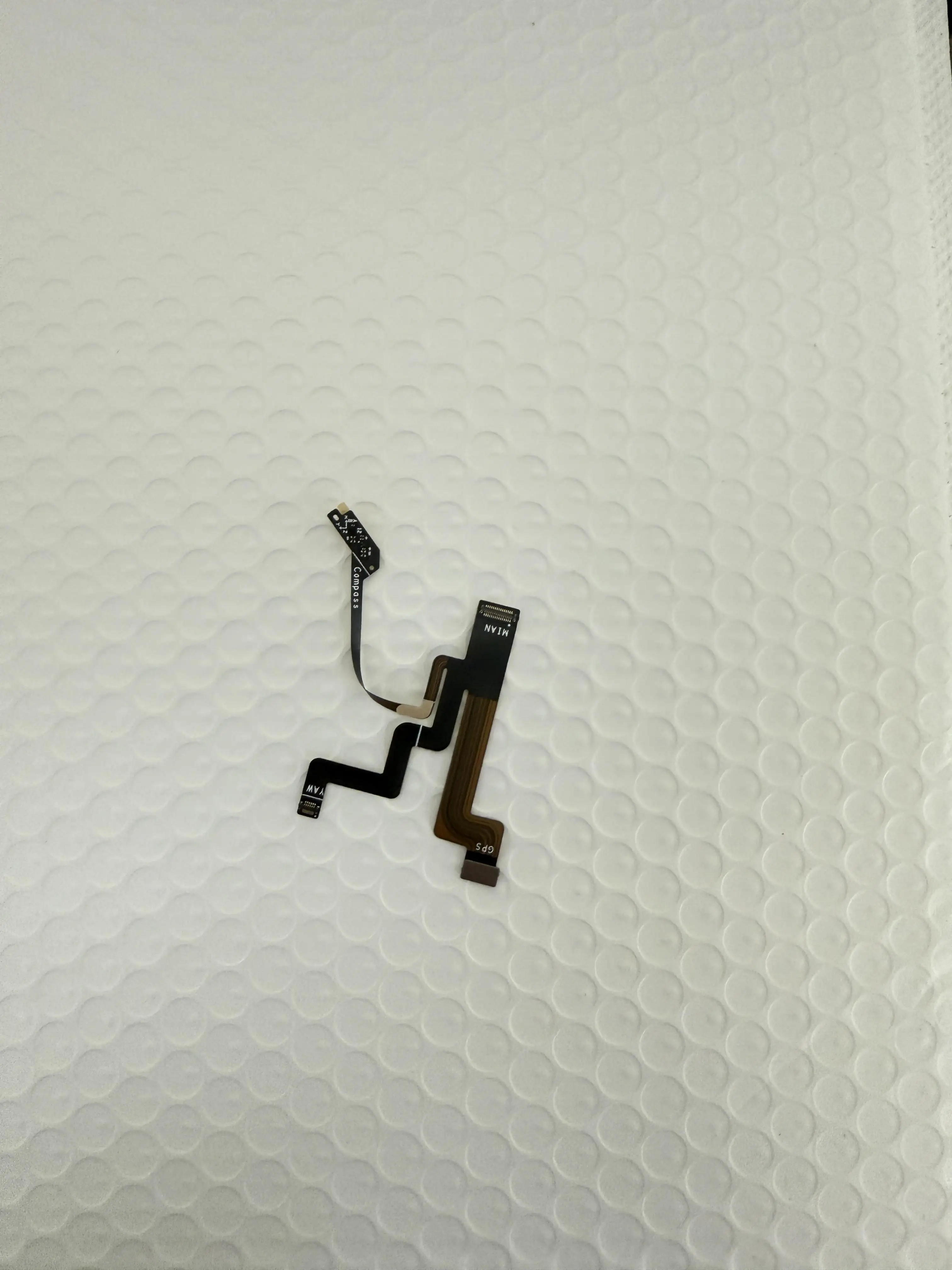 Capteur géomagnétique GPS pour Potensic ATOM 2 posé à côté du drone, avec câble de connexion.